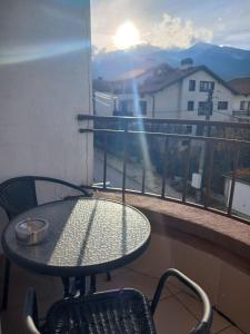 a table and chair on a balcony with a view at Monfort Studio in Bansko