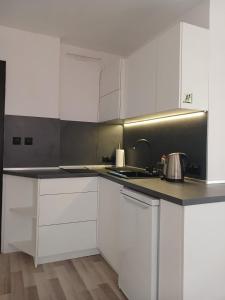 a kitchen with white cabinets and a sink at Monfort Studio in Bansko