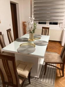 a dining room table with chairs and a white table at Nevade home in Gornji Milanovac