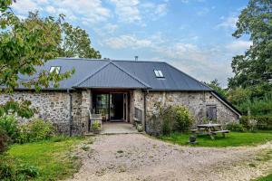 an old stone barn with a black roof at 3 Bed in Dartington oc-b30033 in Darlington