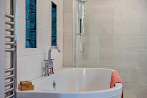 a bathroom with a bath tub with a shower at 3 Bed in Dartington oc-b30033 in Darlington