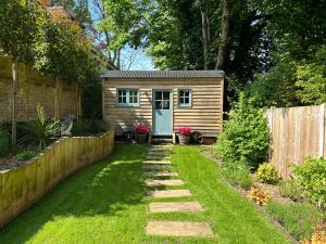 a tiny house in a garden with a yard at Shepherd's Hut at The Granary in Steyning
