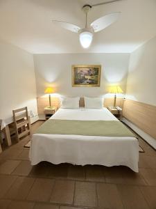 a bedroom with a large bed and two lamps at Hotel Mirante in Barra Velha