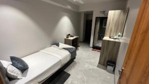 a small bedroom with a bed and a sink at Hotel City View in Golāghāt +11 photos