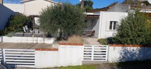 a white fence in front of a white house at Sa Zirighetta in S'archittu Cuglieri