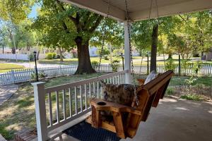 a porch swing with a pillow on a porch at Walkable 2BR Cottage in Downtown Marion in Marion