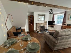 a living room with a table and a couch at Carmel Cottage - Forest of Dean in Lydbrook