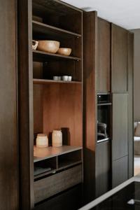a kitchen with wooden cabinets with plates and bowls at BAUA Gartenhaus in Maurach