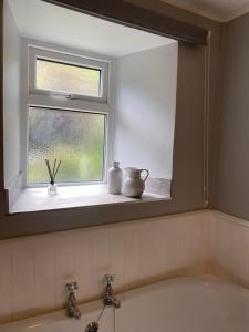 a window above a sink in a bathroom at Carmel Cottage - Forest of Dean in Lydbrook +28 photos