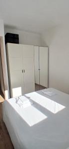 two beds in a room with white cabinets at Sa Zirighetta in S'archittu Cuglieri