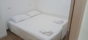 a white bed with two white pillows on it at Sa Zirighetta in S'archittu Cuglieri +25 photos