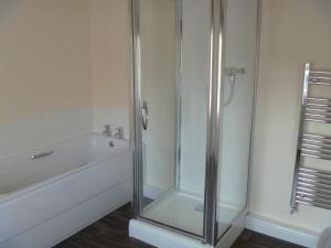 a bathroom with a shower and a tub and a sink at The Lamplighter Dining ~ Rooms in Windermere