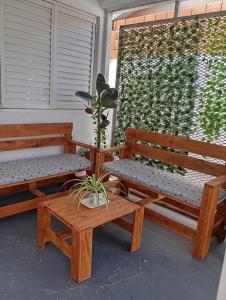 two benches and a potted plant on a porch at Casa Daia con cochera y piscina in Resistencia