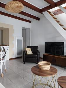 a living room with a black couch and a tv at Maisonette Syl' -vie in Cognac