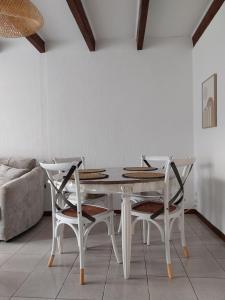 a white dining room table and two white chairs at Maisonette Syl' -vie in Cognac