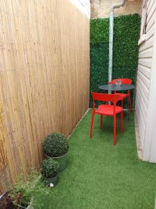 a small patio with a table and a red chair at Maisonette Syl' -vie in Cognac