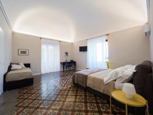 une chambre d'hôtel avec deux lits et un canapé dans l'établissement B&B Sciara Larmisi, à Catane
