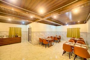 a restaurant with tables and chairs in a room at Hotel Airline Inn - Near Kempegowda International Airport in Muthugadahalli