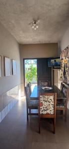 a dining room with a table and chairs and a window at Casa da vila in Imbituba
