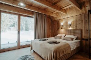 una camera da letto con un grande letto e una grande finestra di Drevia a Istebna