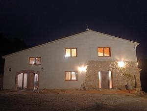 a large white house at night with lights at Masía Can Janàs in Lliçà d'Amunt