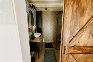 a bathroom with a wooden door and a sink at Chata Szyszka in Męcina Mała +50 photos