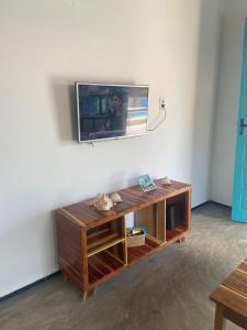 a living room with a tv on a wall at Casa Mar Alto in Icapuí