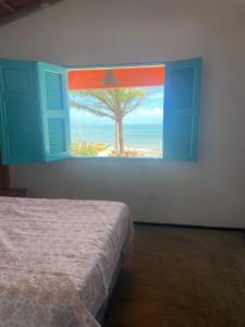 a bedroom with a window with a view of the ocean at Casa Mar Alto in Icapuí +35 photos
