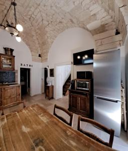 a kitchen and dining room with a wooden table at PETRAKIs HOUSE in Ostuni