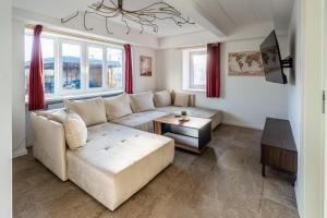 a living room with a white couch and a table at Villa Backstein mit kostenfreien Parkplätzen und 8 E - Ladestationen in Schwerin