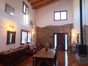 a dining room with a table and a stone wall at Masía Can Janàs in Lliçà d'Amunt