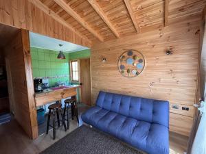 a living room with a blue couch and a bar at Cabañas Sra Mery in Quilimarí