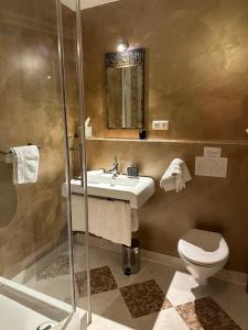 a bathroom with a sink and a toilet and a shower at Gästeresidenz - Hotel - Ruthellen's Home in Planegg