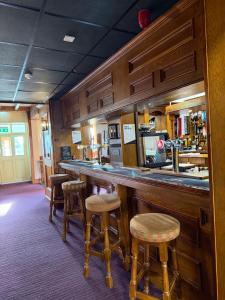 a bar in a restaurant with stools and a counter at Crown & Anchor Inn in Brough