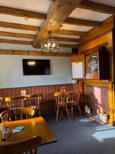a dining room with chairs and a clock on the wall at Crown & Anchor Inn in Brough