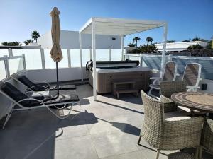 a patio with a hot tub and a table and chairs at Casa Marilyn in Playa Blanca