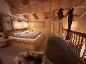 a bedroom with a bed and a tub in a room at Chalet am Bachl 2 in Flattach