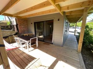a deck with a table and chairs on a house at SeaGarden Cottage in Cape St Francis
