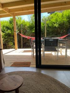 a screened in porch with a table and a hammock at SeaGarden Cottage in Cape St Francis +2 photos