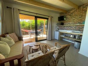 a living room with a couch and chairs and a table at SeaGarden Cottage in Cape St Francis