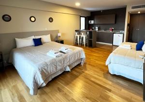 a hotel room with two beds and a kitchen at Apart Hotel Quijote by DOT Suites in Ciudad Lujan de Cuyo