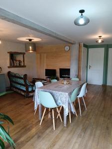 a dining room with a table and white chairs at L étable au naturel in Mauriac