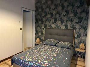 a bedroom with a bed with a floral wallpaper at La petite maison in Rimaucourt