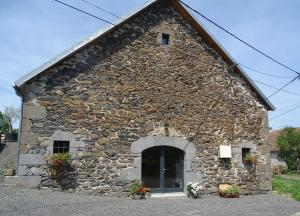 a stone church with flowers in front of it at L étable au naturel in Mauriac