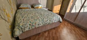 a bedroom with a bed with a floral bedspread at Appartement stylia 2 in Agadir