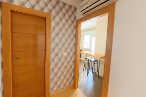 a hallway with a wooden door and a table at Piso 3 Dormitorios in La Roda