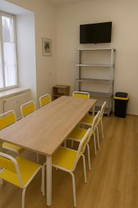 a conference room with a wooden table and yellow chairs at Pension na hranici in Železná Ruda