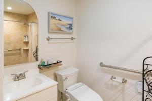 a white bathroom with a toilet and a sink at Bright, Spacious Home with Private Deck in Potomac