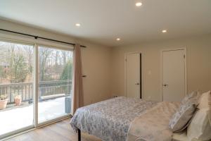 a bedroom with a bed and a large window at Bright, Spacious Home with Private Deck in Potomac