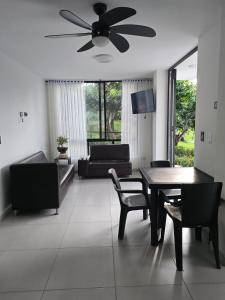 a living room with a ceiling fan and a table and chairs at El Ensueño - Rest House in La Mesa